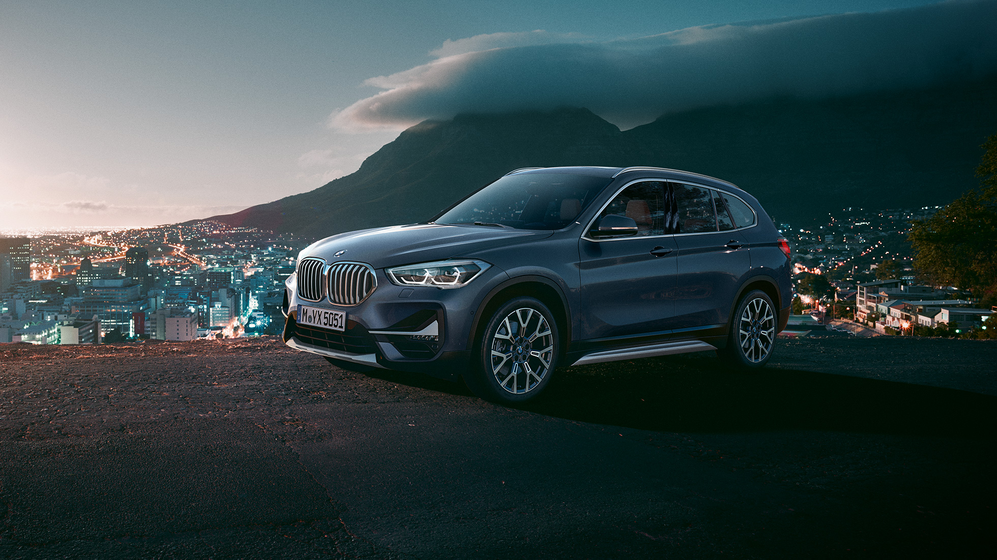 BMW X1, kolm neljandikku külgvaade. BMW X1, kolm neljandikku külgvaade, seismas linna taustal.