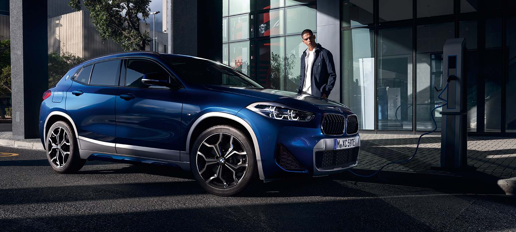 Pistikhübriid BMW X2 xDrive25e F39 kolm neljandikku külgvaade, laadimisjaamas Pistikhübriid BMW X2 xDrive25e F39 kolm neljandikku külgvaade, laadimisjaamas koos modelliga