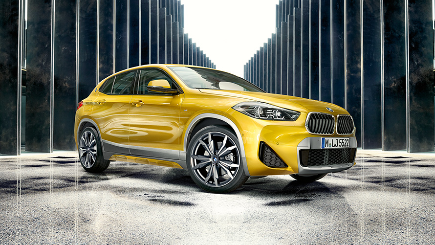 BMW X2 F39, Brooklyn Grey, kolm neljandikku tagantvaade koos avatud ukse ja kahe inimesega BMW X2 F39, Brooklyn Grey, kolm neljandikku tagantvaade koos avatud ukse ja kahe inimesega