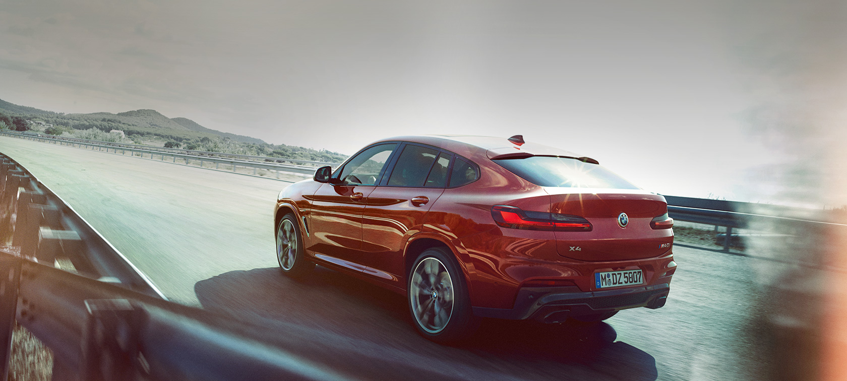BMW X4 M40i G02 2018 toonis Flamenco Red Brilliant Effect, 3/4 tagantvaade, teel sõitmas