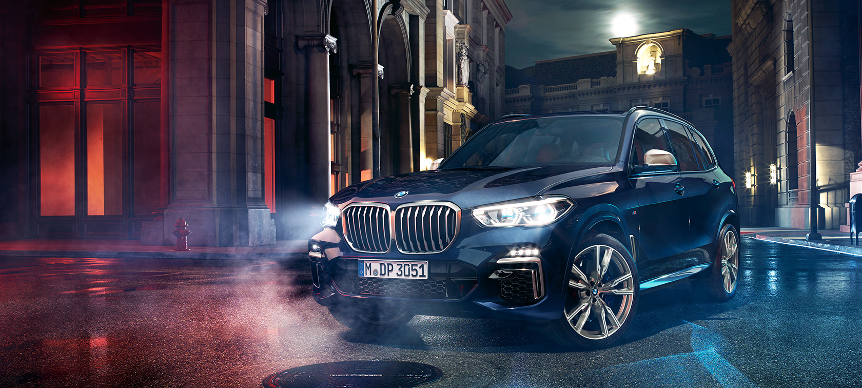 BMW X5 M50d teel BMW X5 M50d seisab teel öise linna taustal