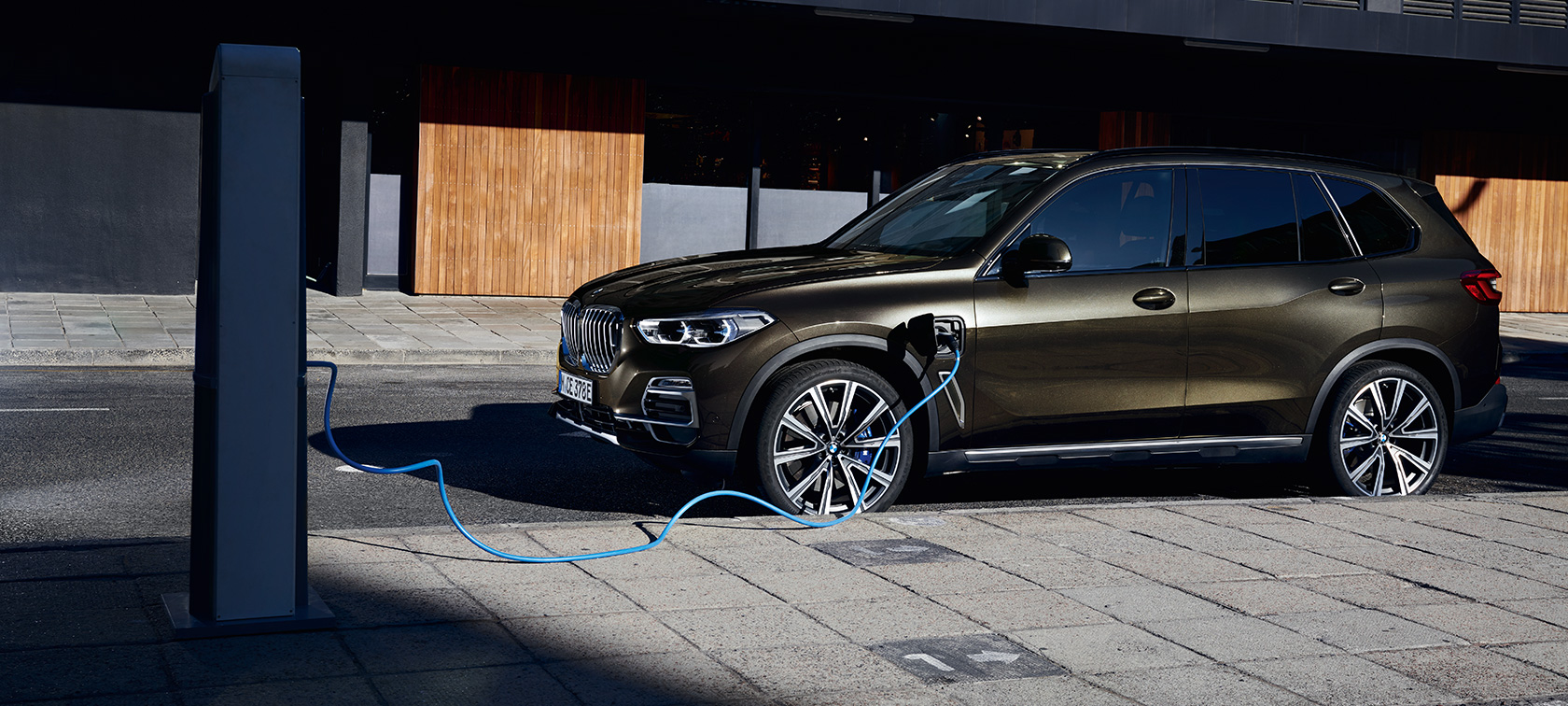 Pistikhübriid BMW X5 xDrive45e G05, kolm neljandikku külgvaade Pistikhübriid BMW X5 xDrive45e G05, kolm neljandikku külgvaade, laadimas