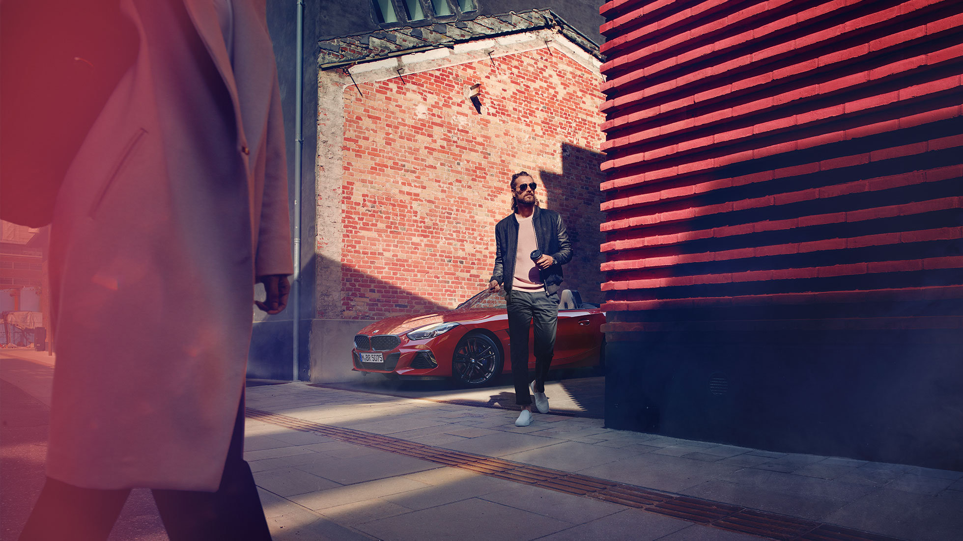 BMW Z4 Roadster kõrvaltänaval Mees kõrvaltänavas BMW Z4 Roadsteri ees