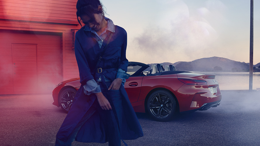 BMW Z4 M40i Roadster G29, avatud pehme katusega BMW Z4 M40i Roadster G29, kolm neljandikku tagantvaade avatud pehme katusega, naine esiplaanil
