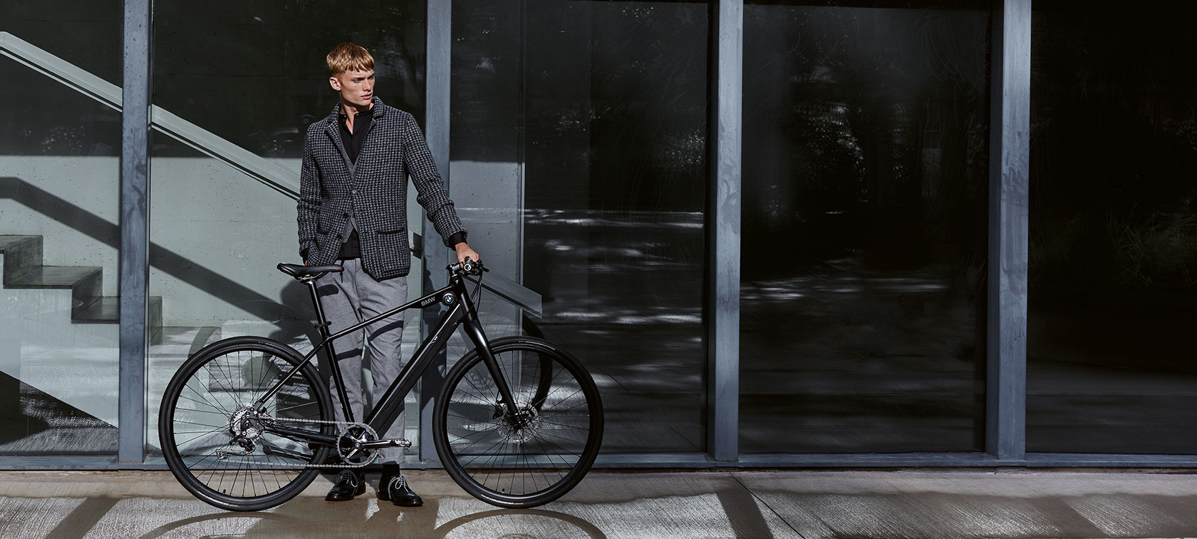 Disain ja funktsioon. Mees seisab tavapärases poosis BMW Urban Hybrid E-Bike’i kõrval.