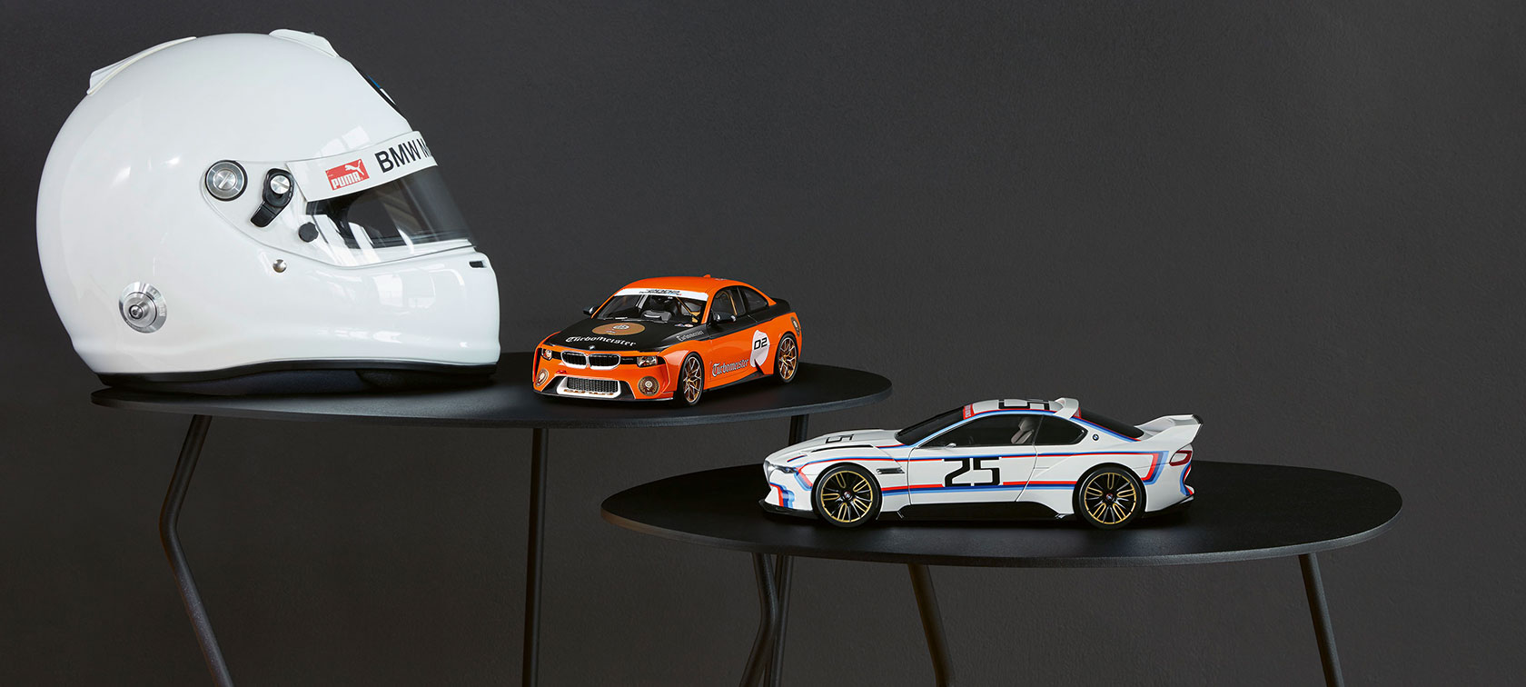 Pildil on miniatuurne BMW 2002 Homage Turbomeister ja miniatuurne BMW 3.0 CSL 25 asetatud paremale, valge kiivri kõrvale. Pildil on miniatuurne BMW 2002 Homage Turbomeister ja miniatuurne BMW 3.0 CSL 25 asetatud paremale, valge kiivri kõrvale.