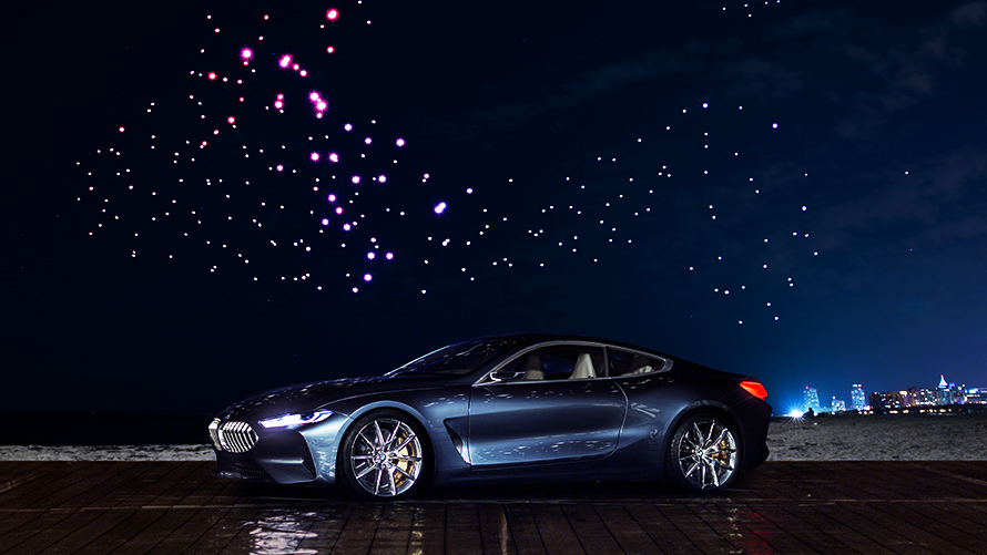 BMW Concepti 8. seeria BMW 8. seeria Concept ümbritsetud 300 valgustatud lendava drooniga öises taevas
