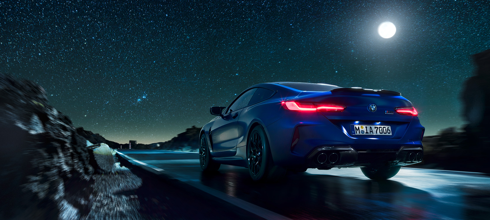 BMW M8 Competition Coupé, tagantvaates. BMW M8 Competition Coupé, tagantvaates, sõites täiskuuöös.