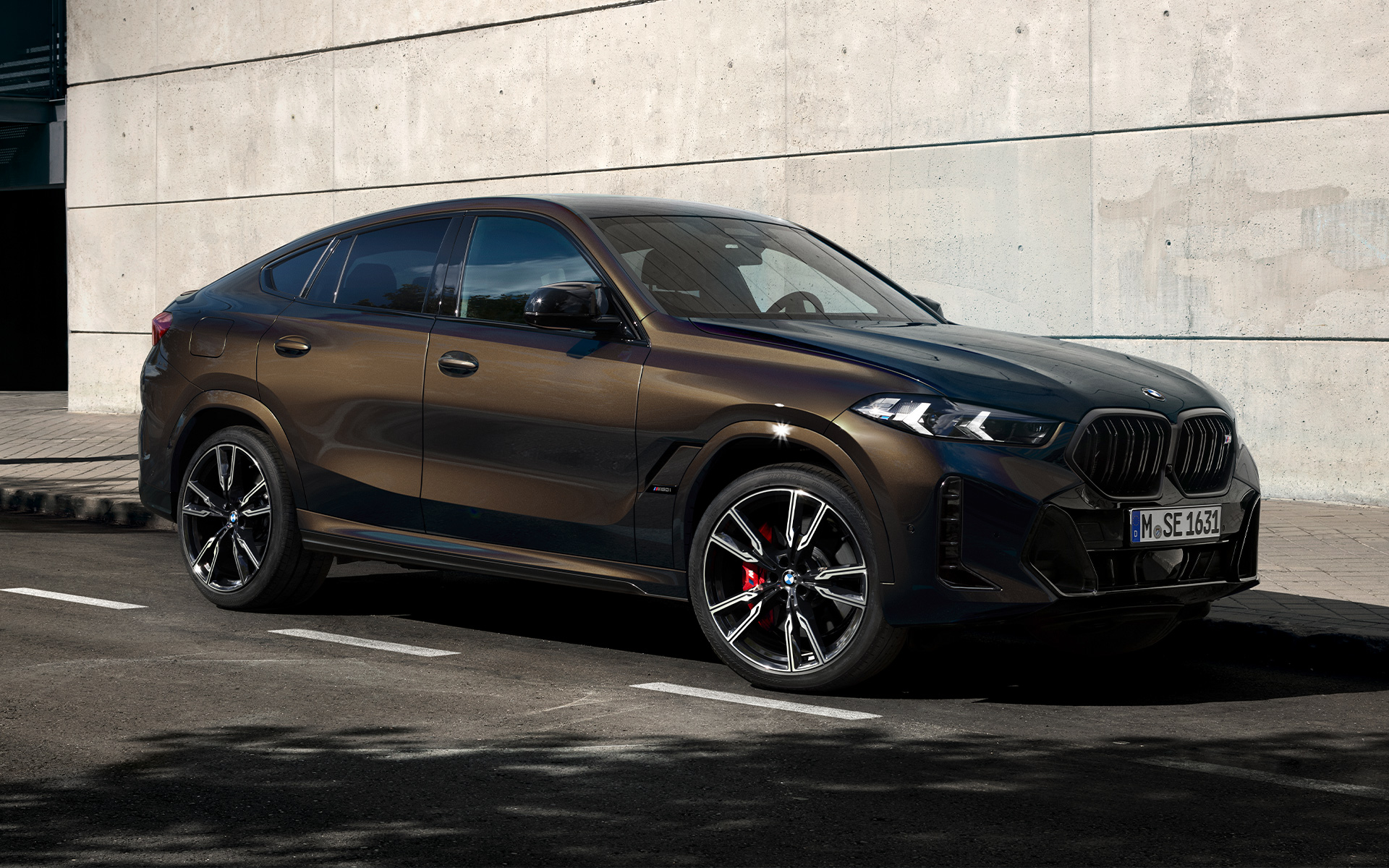 BMW X6 M60i G06 värvitoonis BMW Individual Pyrite Brown metallik, 2/3 külgvaade, parklas parkimas