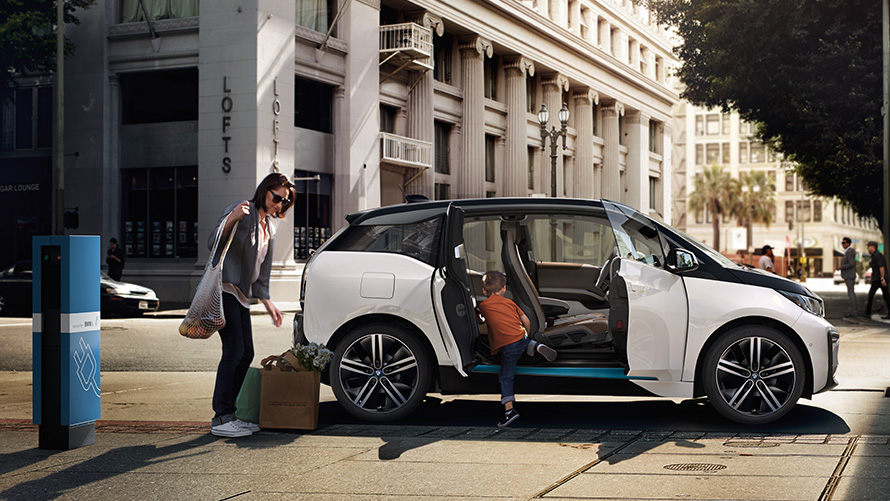 BMW i3 linna taustal BMW sõiduulatus, BMW i3 linna taustal koos naise ja lapsega