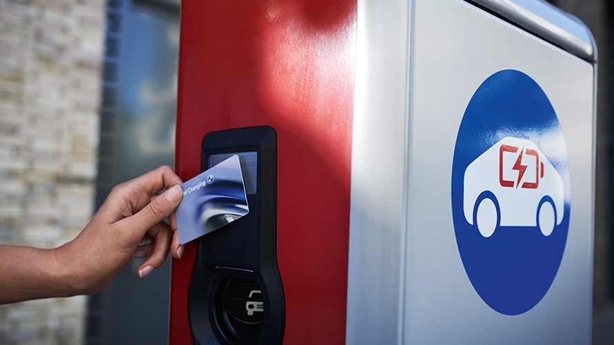 Avalikus laadimispunktis laadimine BMW Charging Cardiga Isik hoiab BMW Charging Cardi avalikus laadimisjaamas
