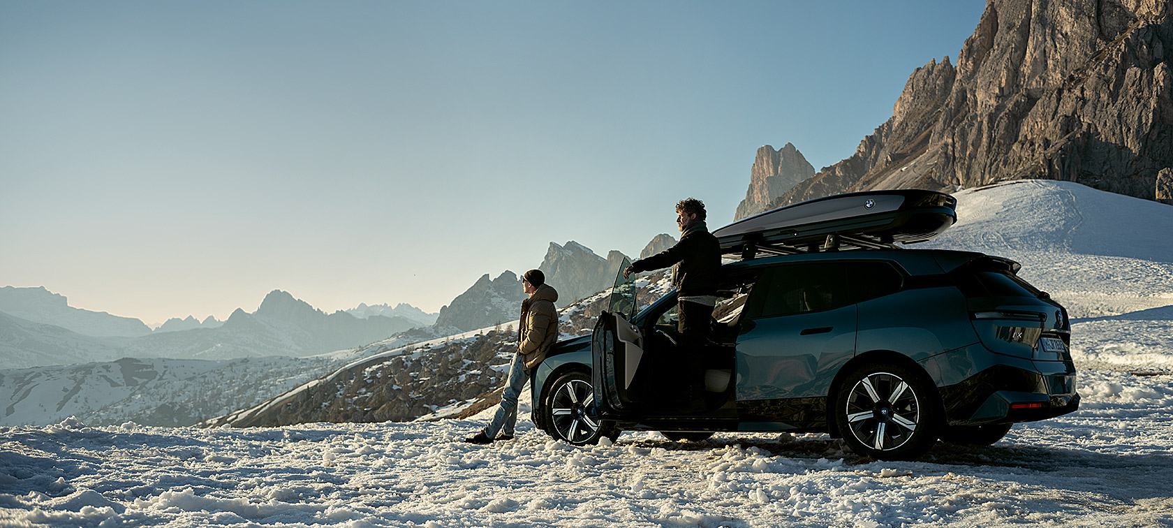 Mehed BMW iX-iga lumisel maastikul