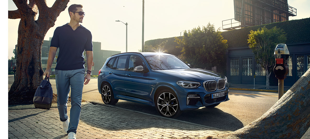 Päikeseprillidega mees sinise BMW ees Päikeseprillidega mees sinise BMW ees